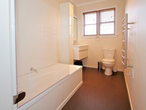 Bathroom features a bathtub, toilet, and sink.