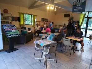 A dining area with tables and chairs, a display of books, and a banner advertising a property.