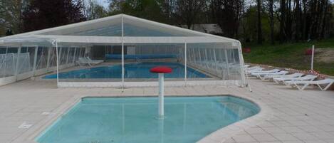 Indoor pool, a heated pool, open 10:00 AM to 9:00 PM, pool umbrellas