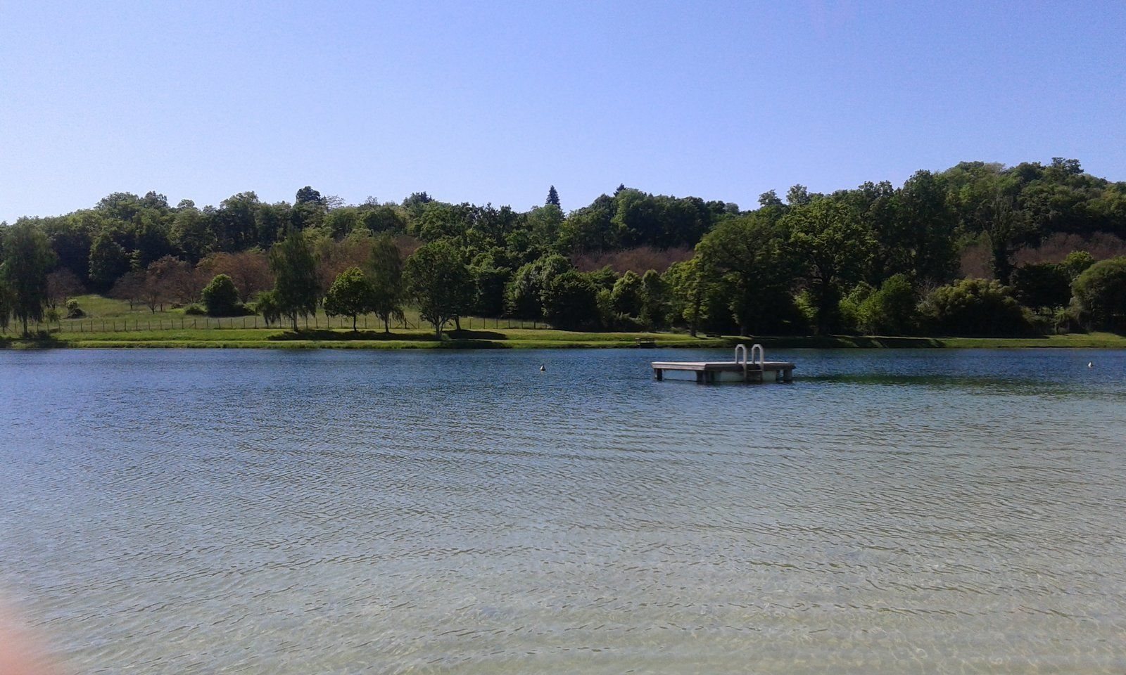 Un lago con un muelle y un banco.