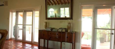 Una habitación con un armario de madera, un espejo y piso de baldosas.