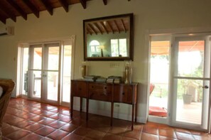 A room with a wooden cabinet, a mirror, and a tiled floor. - Coconut Tree Villa (East End)