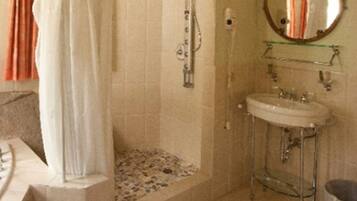 A bathroom with a shower, a sink, and a mirror.