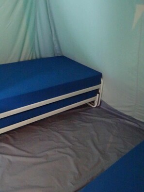 Een stapelbed met een blauwe matras en een wit frame, op een grijs stoffen oppervlak.