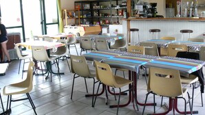 A cafeteria with tables and chairs, a counter with various food items, and a sign indicating a private dining area.