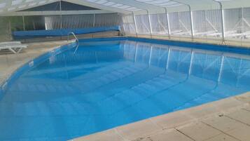 Una piscina techada, sillones reclinables de piscina