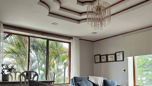 A modern bedroom with a bed, a sofa, and a chandelier. - Casa Familiar la Tortuga (San Pablo)