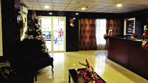 Un vestíbulo con mostrador de recepción, un gran árbol de Navidad y una zona de estar.