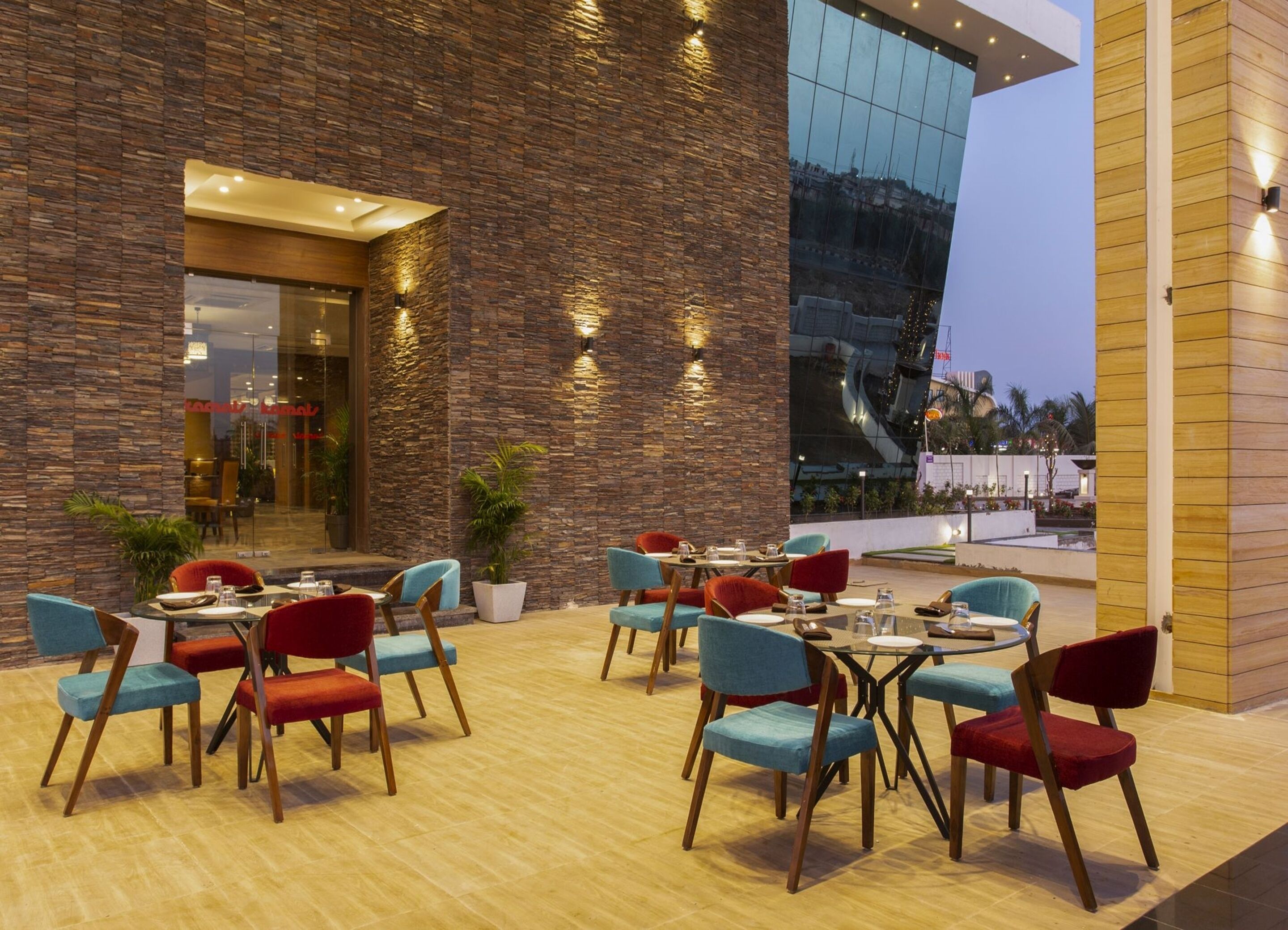 An outdoor dining area with stone walls and modern furniture.