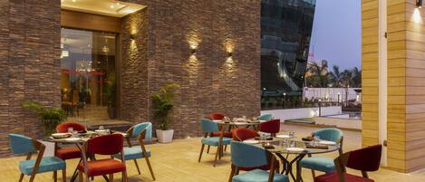 An outdoor dining area with stone walls and modern furniture.