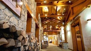 A corridor with stone walls, wooden beams, and a wooden ceiling. - Hôtel Les Sherpas (Courchevel)