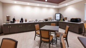 A modern kitchen with a dining area, equipped with appliances and seating. - Hawthorn Extended Stay by Wyndham Odessa (Odessa)