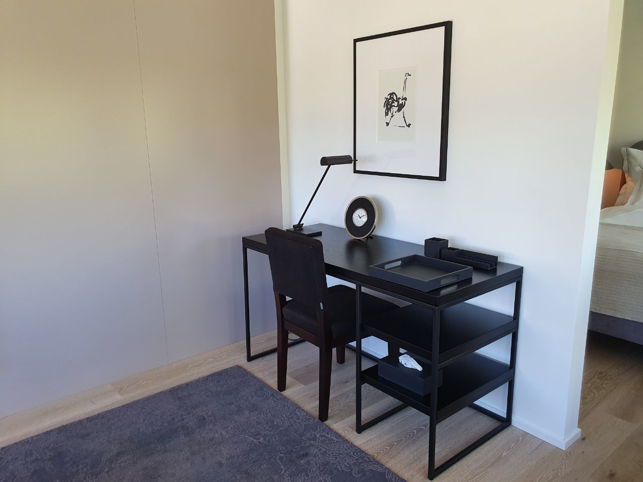 Un petit bureau moderne, équipé d’un bureau, d’une chaise et d’étagères.