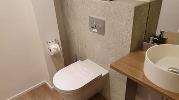 A small bathroom with a toilet, a sink, and a mirror.