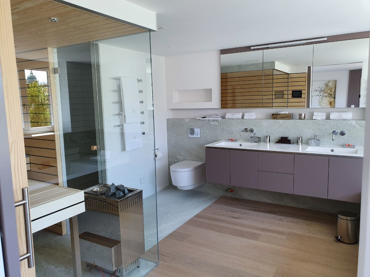 A modern bathroom with a glass shower enclosure, a double sink vanity, and a large mirror.