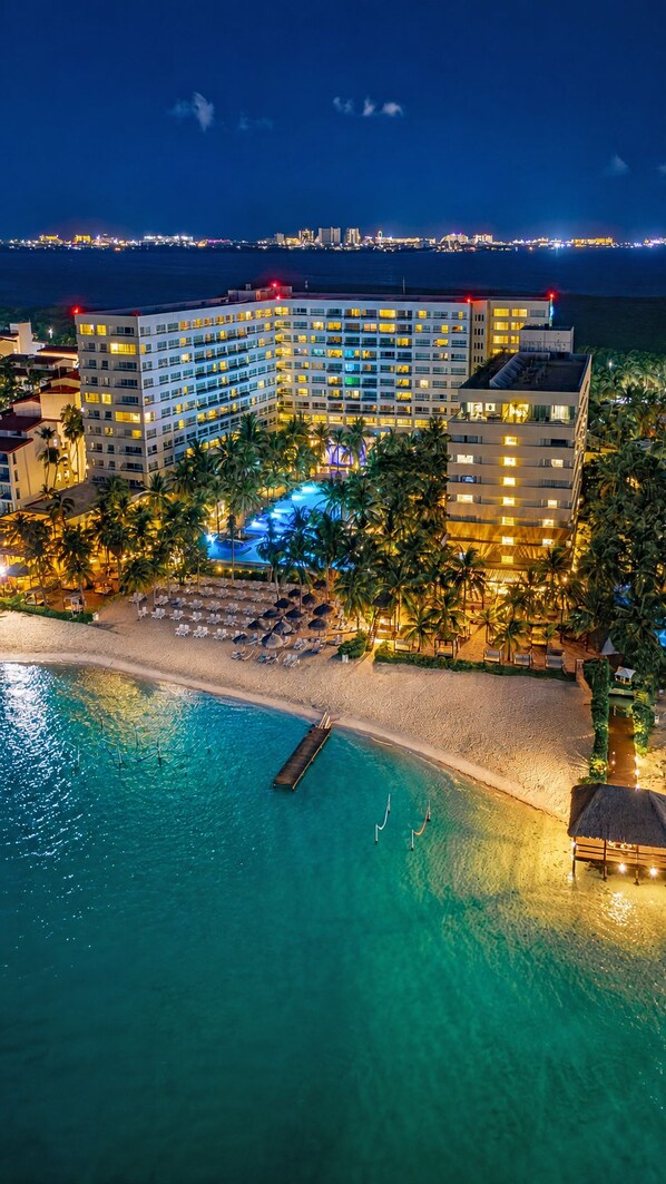 A resort with a pool, beach, and a view of the city skyline at night. - The Sens Cancun By Oasis (Cancun)