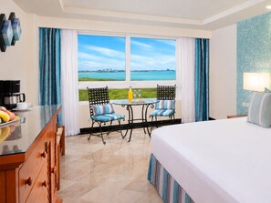 A hotel room with a bed, a dining table with chairs, a coffee station, and a view of the sea. - The Sens Cancun By Oasis (Cancun)