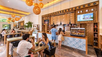 Un café moderno con mostrador central, zona de estar e iluminación decorativa.