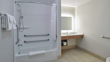 A bathroom with a bathtub, a toilet, a sink, and a mirror.