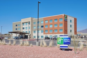 Un hotel Holiday Inn Express dal design moderno, con diversi piani e un parcheggio di fronte.