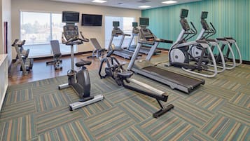 Un gimnasio equipado con cintas de correr, elípticas y máquinas de pesas.