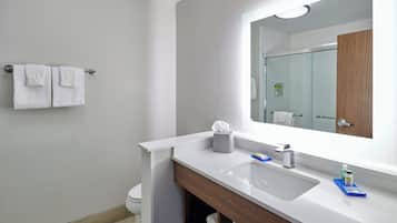 Een moderne badkamer met een witte wastafel, een spiegel en een handdoekrek.