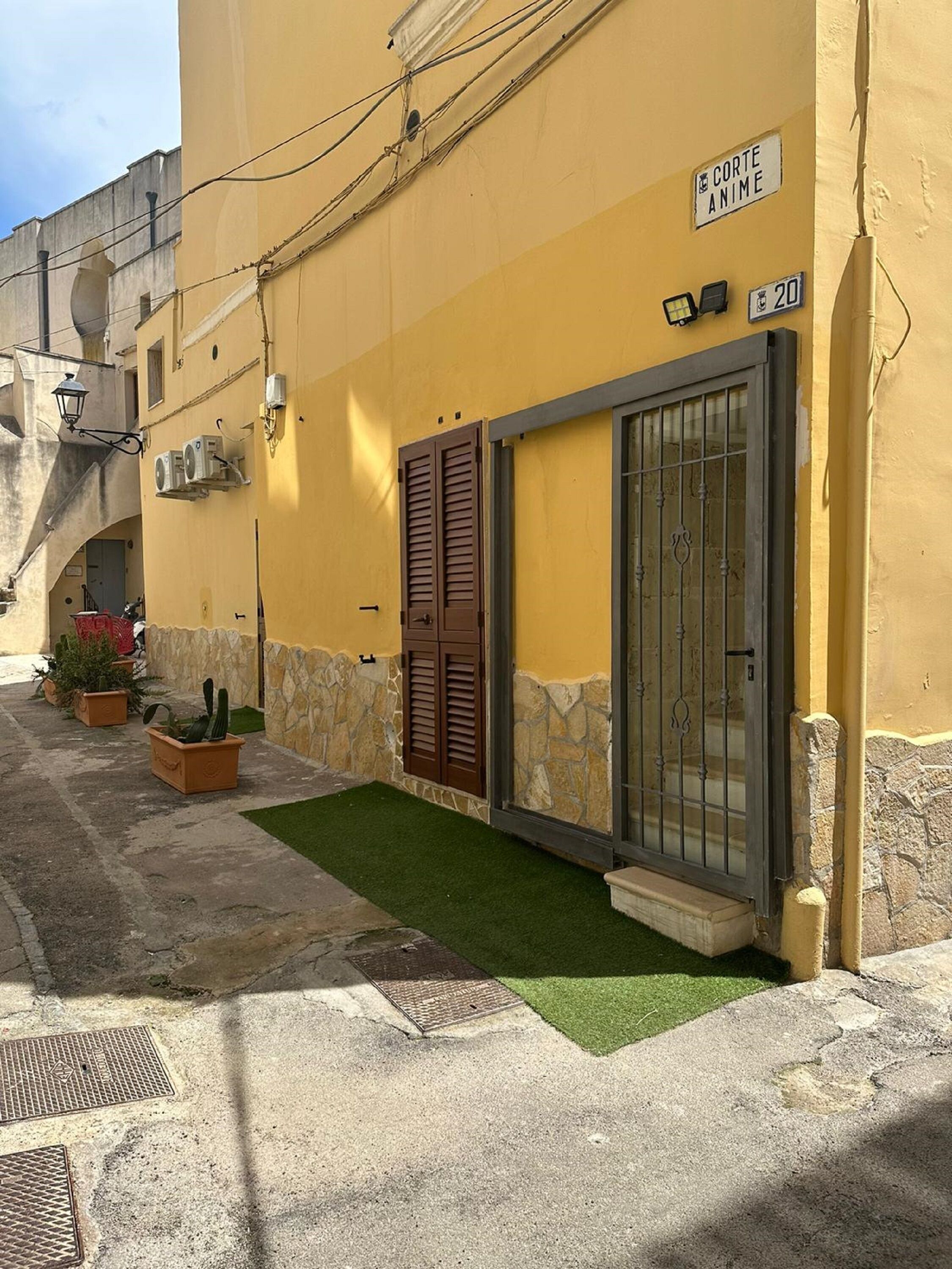 A yellow building with a sign reading "Corte Anime" and a number "20" on the wall.