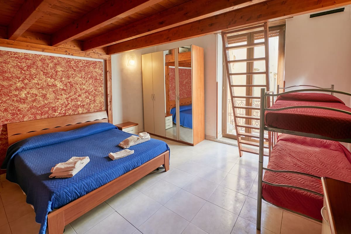 A bedroom with a wooden bed, a wardrobe, and a bunk bed.