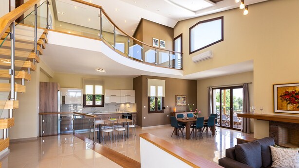 A spacious living area with a modern staircase, a dining area, and a kitchen. - Anatoli Villa, a Retreat with Private Pool & BBQ (Rethymno)