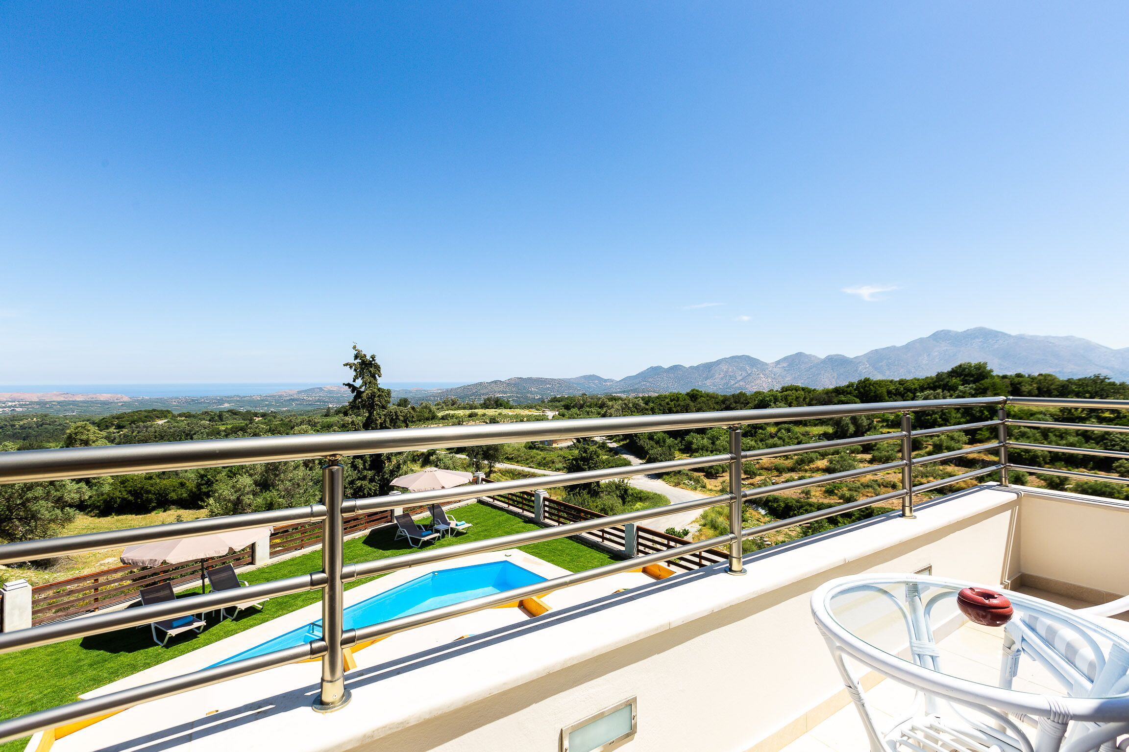 Un balcón con piscina, mobiliario exterior y vistas a las montañas.