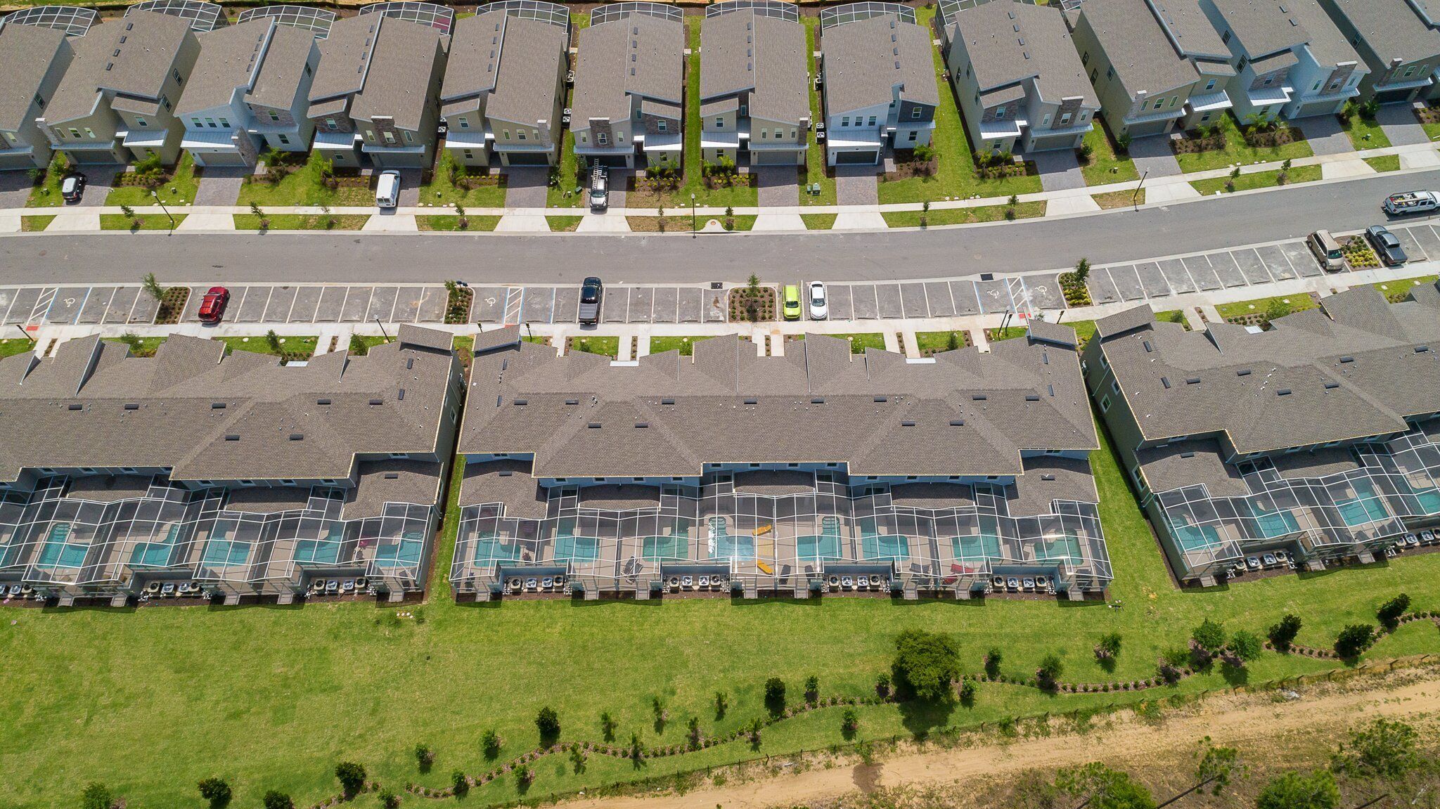 A residential complex with multiple apartment buildings, a parking lot, and a swimming pool area.
