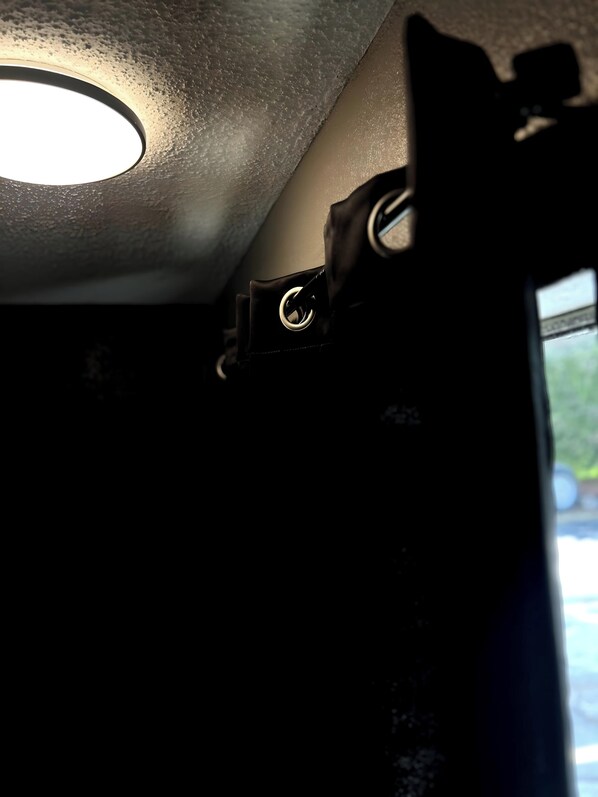 A ceiling with a recessed light fixture and a metal bracket.