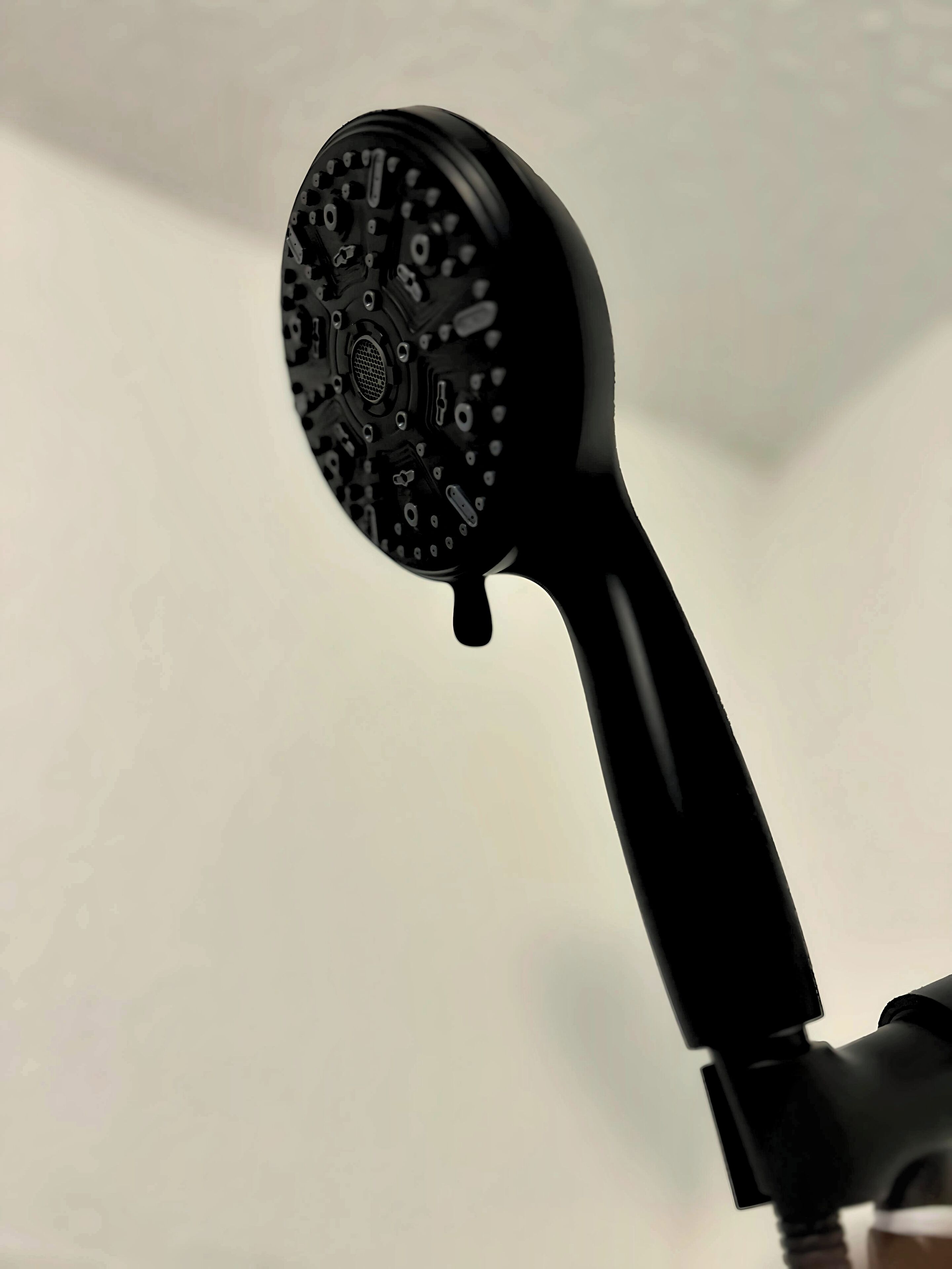 A black object with a circular top and a handle, possibly a piece of equipment or a device.