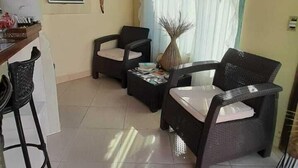 A spacious living area with a high ceiling, a dining area with a bar, and a large window with sheer curtains. - Mares de Camburizinho (São Sebastião)