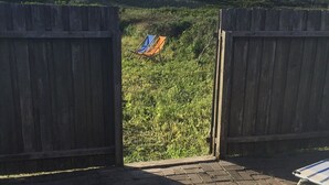 An open patio with a view of a grassy field and a blue and orange chair. - In the first row to the North Sea (Thyboron)