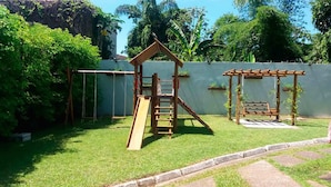 Ein Spielplatz mit einer hölzernen Kletterkonstruktion und Schaukeln.