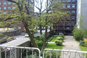 Stunning city views from a balcony overlooking a beautifully manicured garden.
