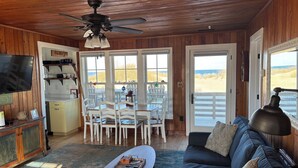 L'intérieur d'un chalet accueillant, avec un coin repas, un canapé et un téléviseur.