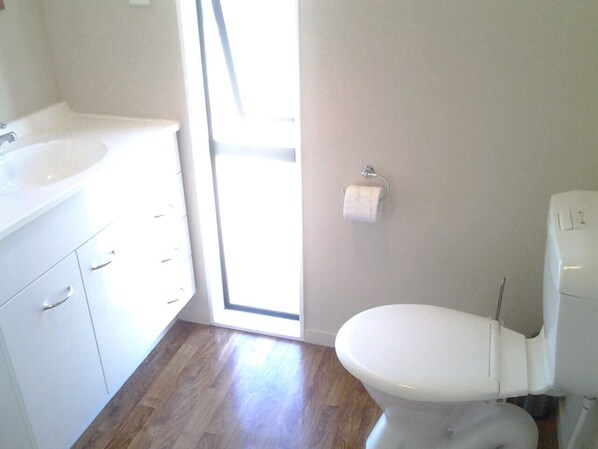 Ein Badezimmer mit Toilette, Waschbecken und Stauraum.