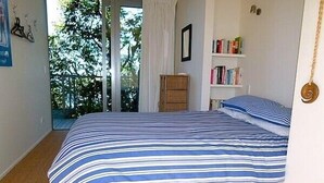 Ein Schlafzimmer mit einem großen Bett, einem Bücherregal und einer Tür, die auf einen Balkon führt.