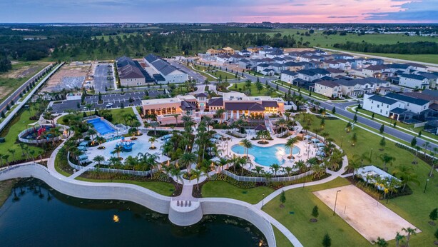 Vista aérea de una zona residencial con piscina central, jardines ajardinados y varias casas.