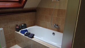 A bathroom with a bathtub, a shower, and a small rug. - Loft in Red Light District (Antwerpen)