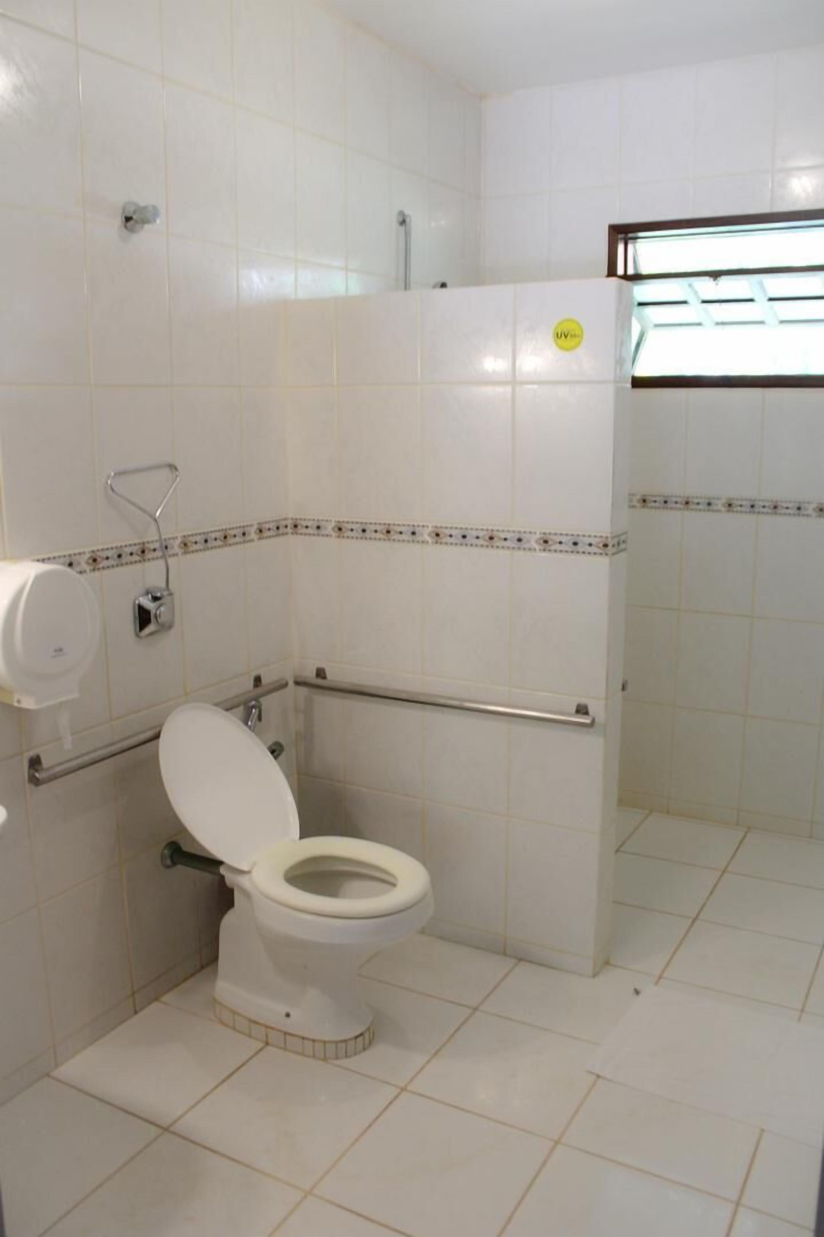 Een kleine, schone badkamer met toilet, handdroger en douchecabine.