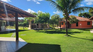 A courtyard with a tiled patio, a brick structure, and a palm tree.