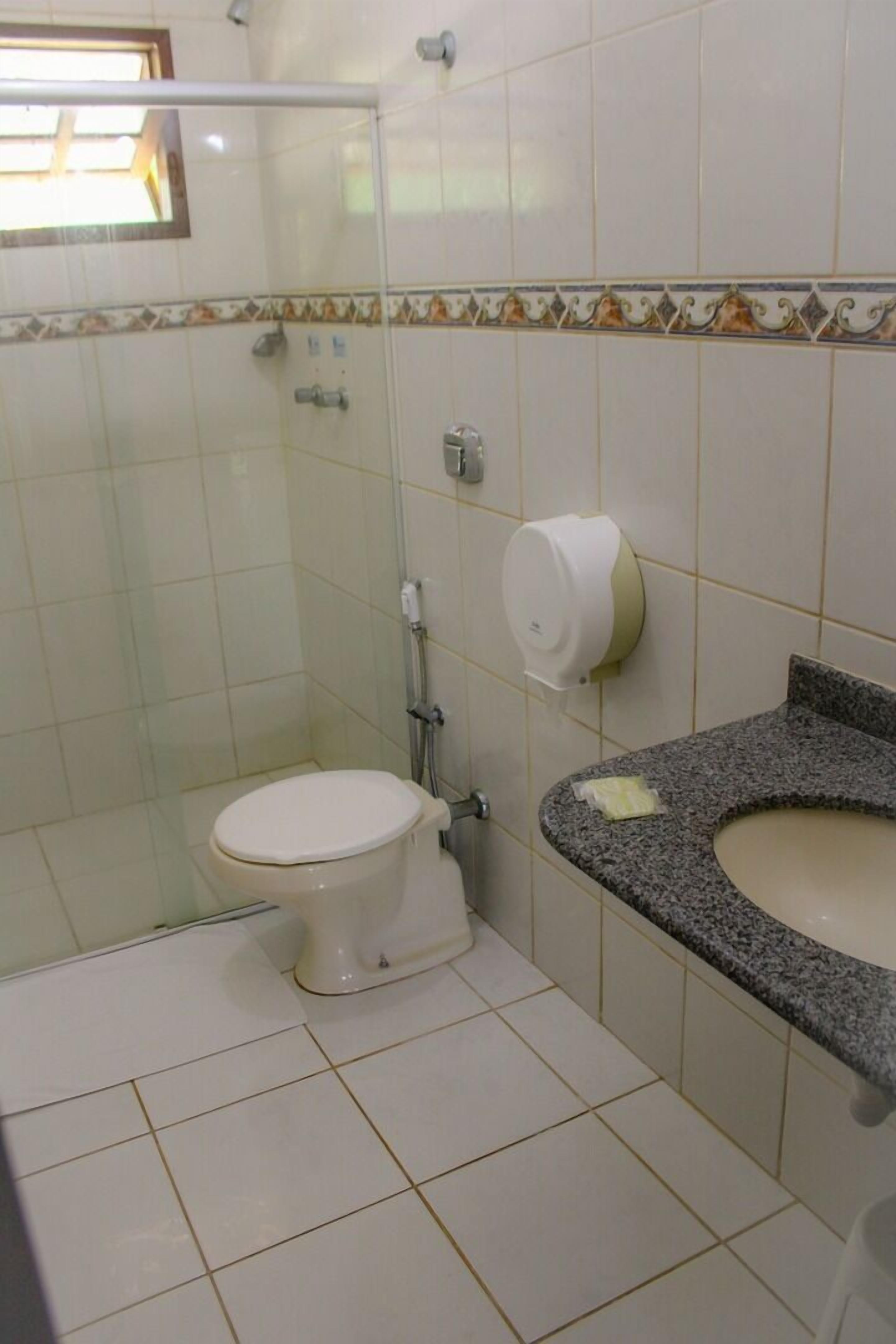 A bathroom with a toilet, a sink, and a shower.