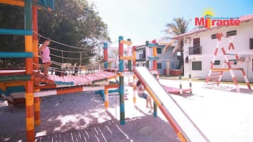 A playground with a rope bridge, slides, and a climbing structure.