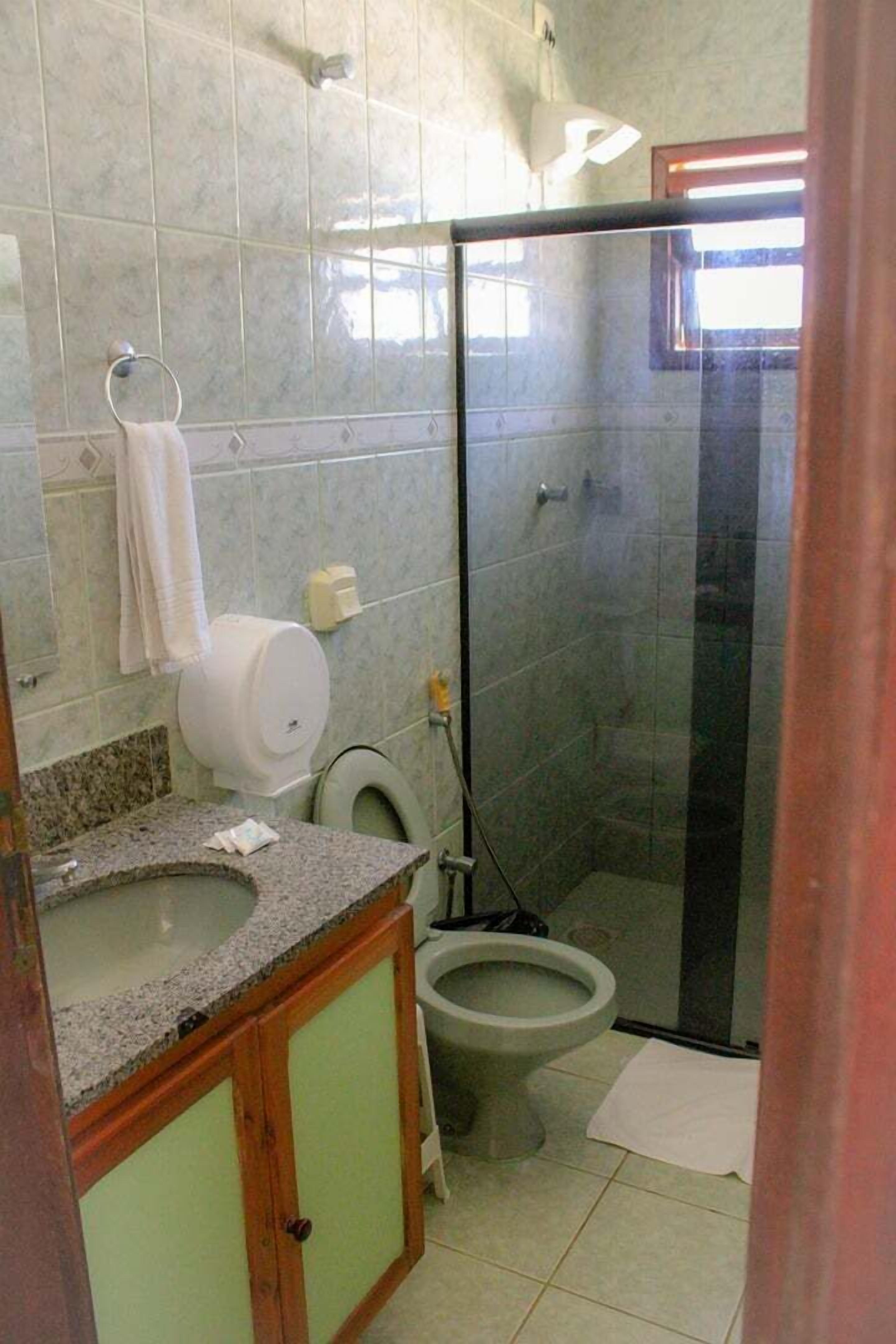 Ein Badezimmer mit Toilette, Waschbecken und Duschbereich.