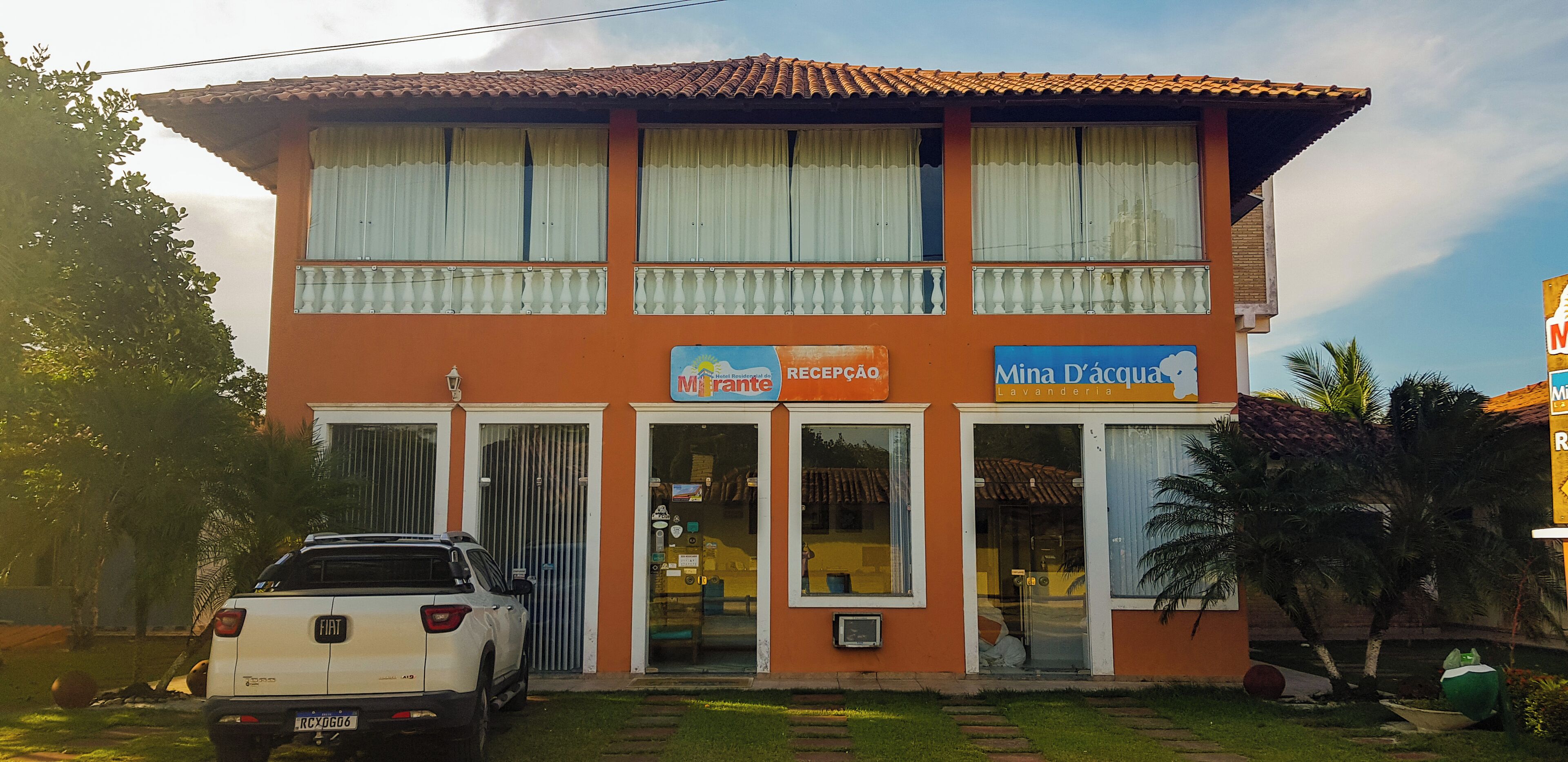 A two-story building with a reception area and a sign for 'Mina D'água'.