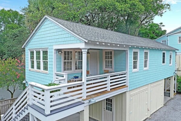 A two-story house with a covered porch and a small deck.