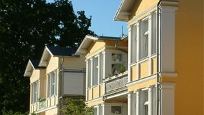 Files de cases grogues amb adorns blancs i nombrosos balcons.